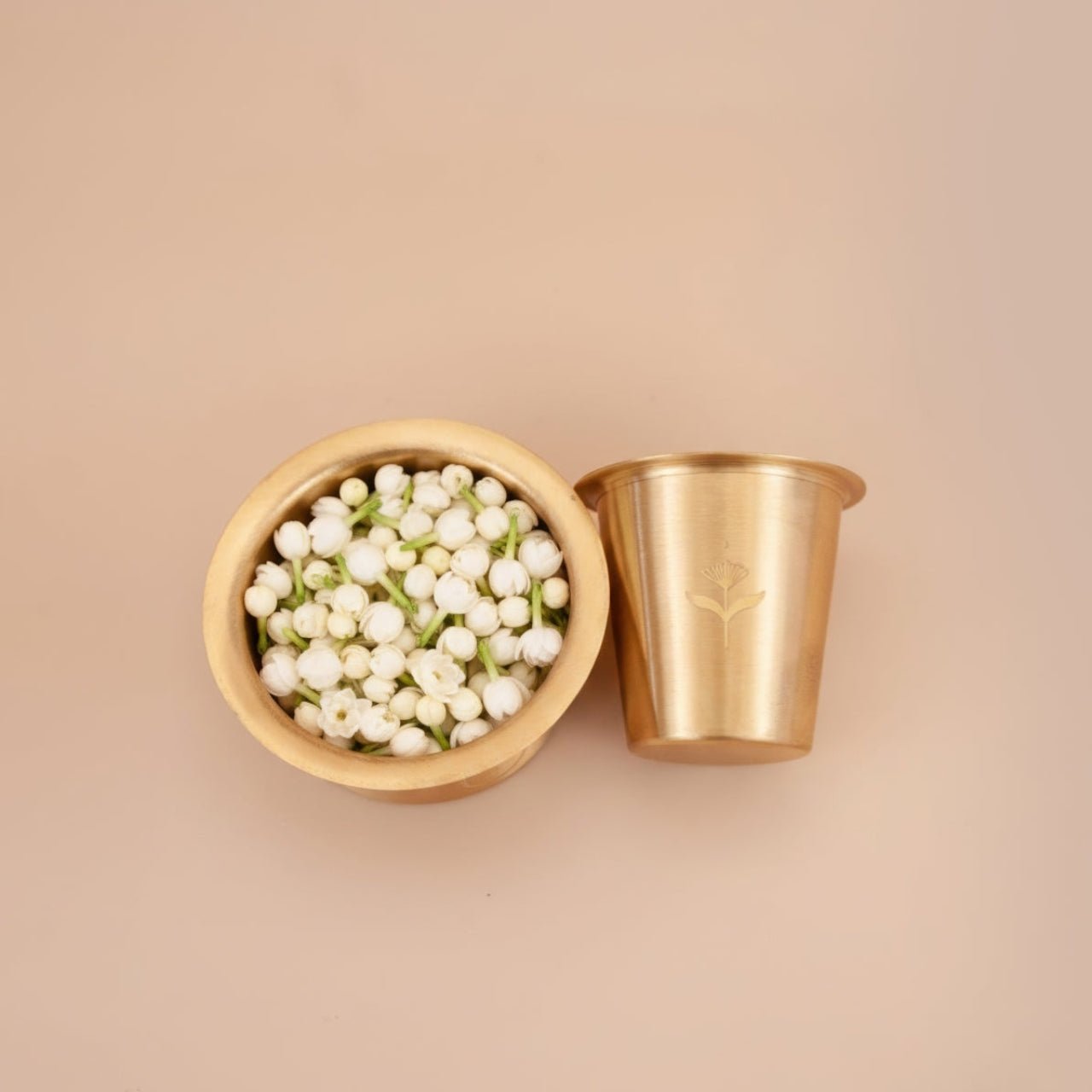 brass coffee tumbler and bowl with white flowers