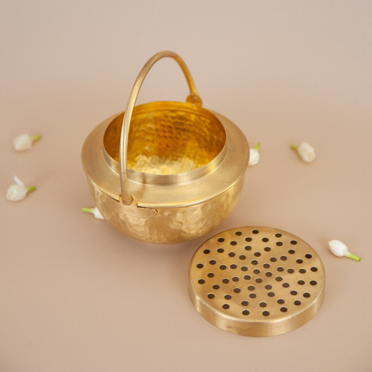 Brass incense burner with lid on a beige background