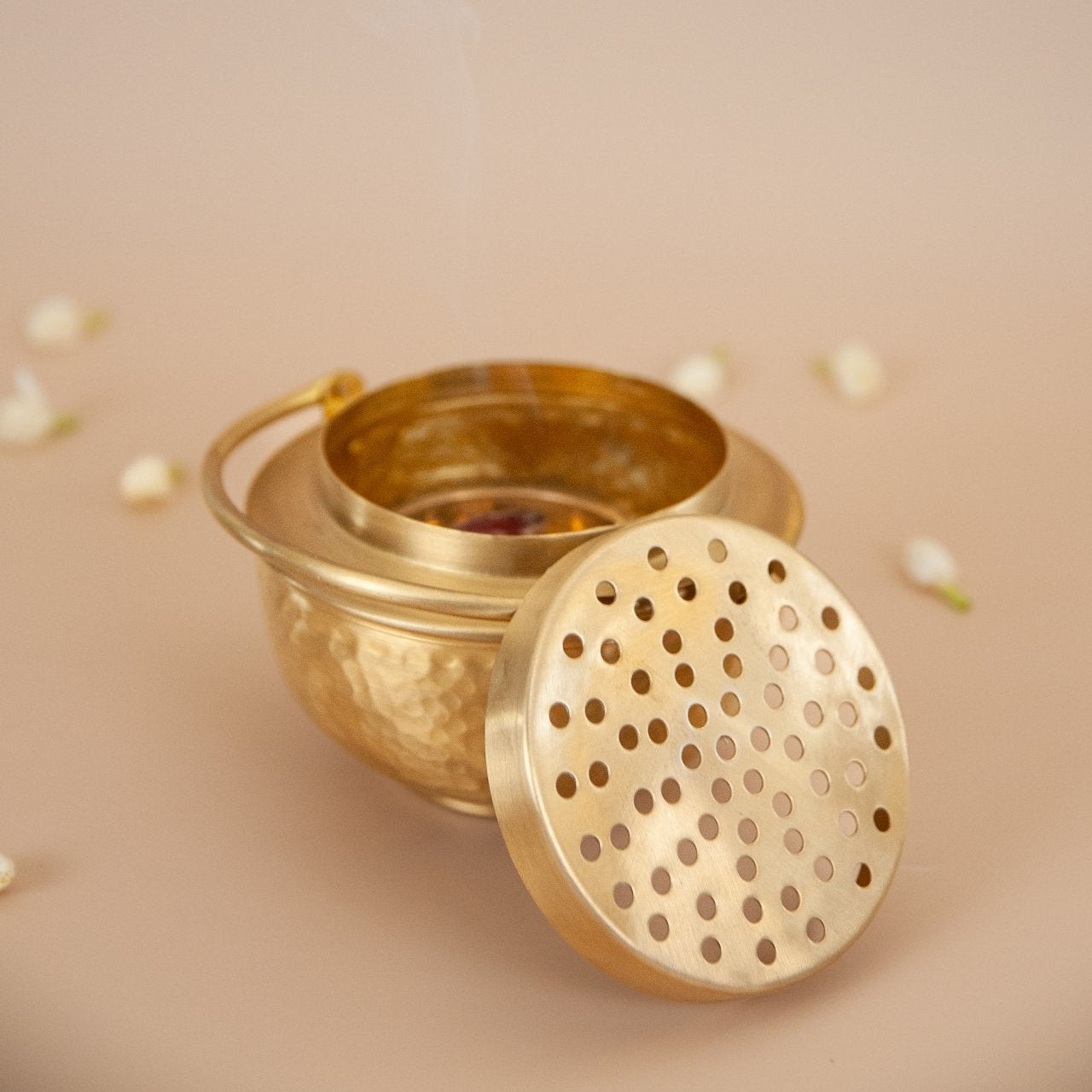 Brass incense burner with lid on a beige background