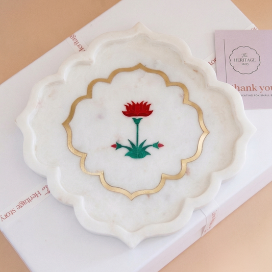 Decorative marble platter with floral inlay design on a pink background