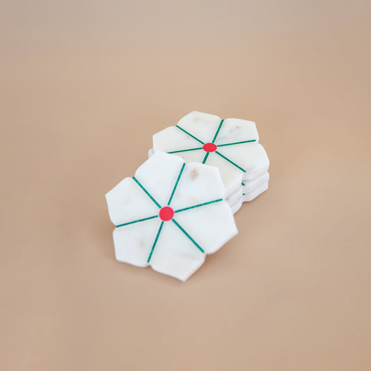 White marble coaster with red centers and green lines on a beige background