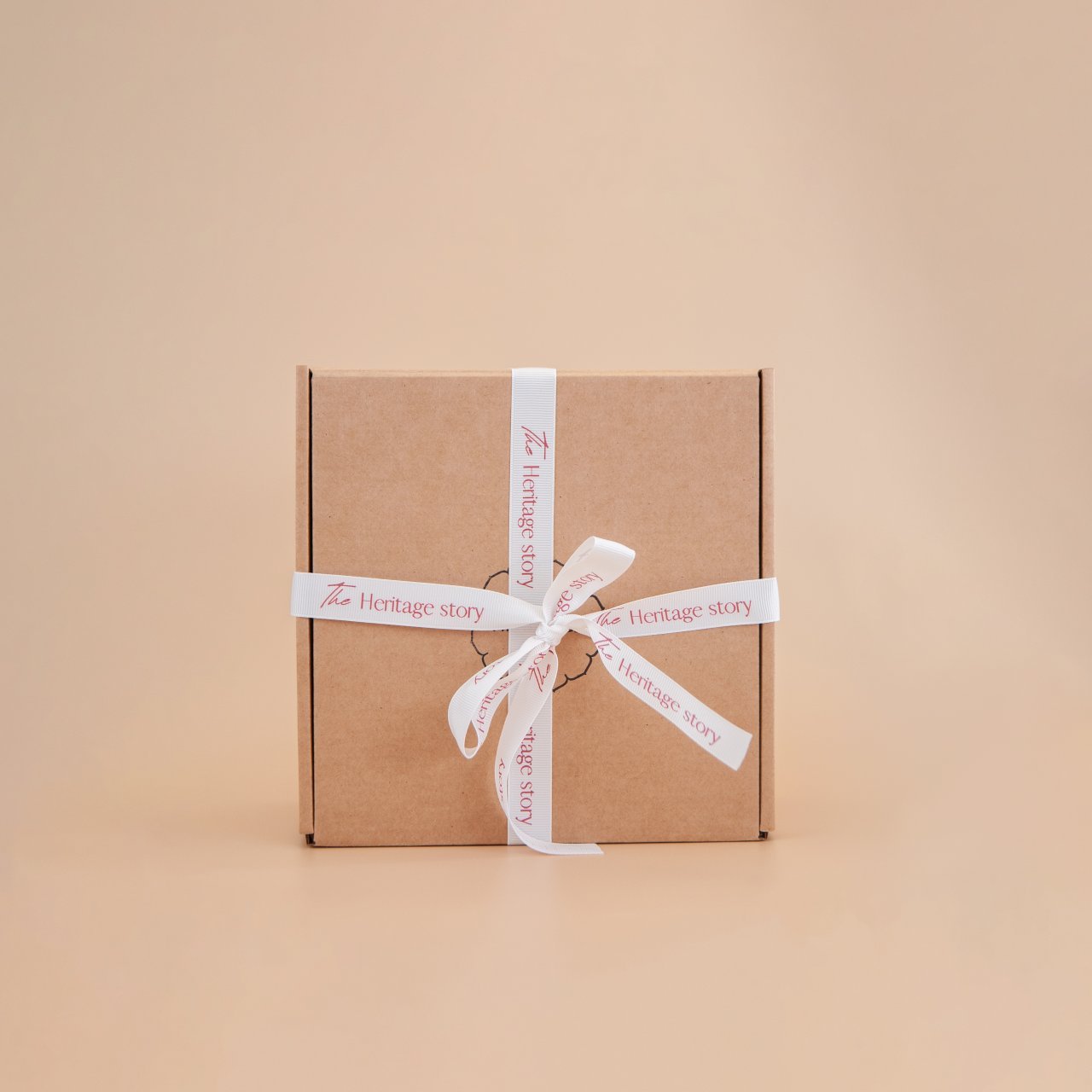 Brown box with a white Heritage story ribbon on a beige background